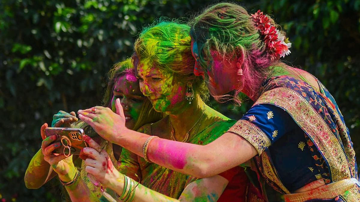 Foreign nationals play Holi during 'Dol Jatra' festival celebrations, in Howrah.