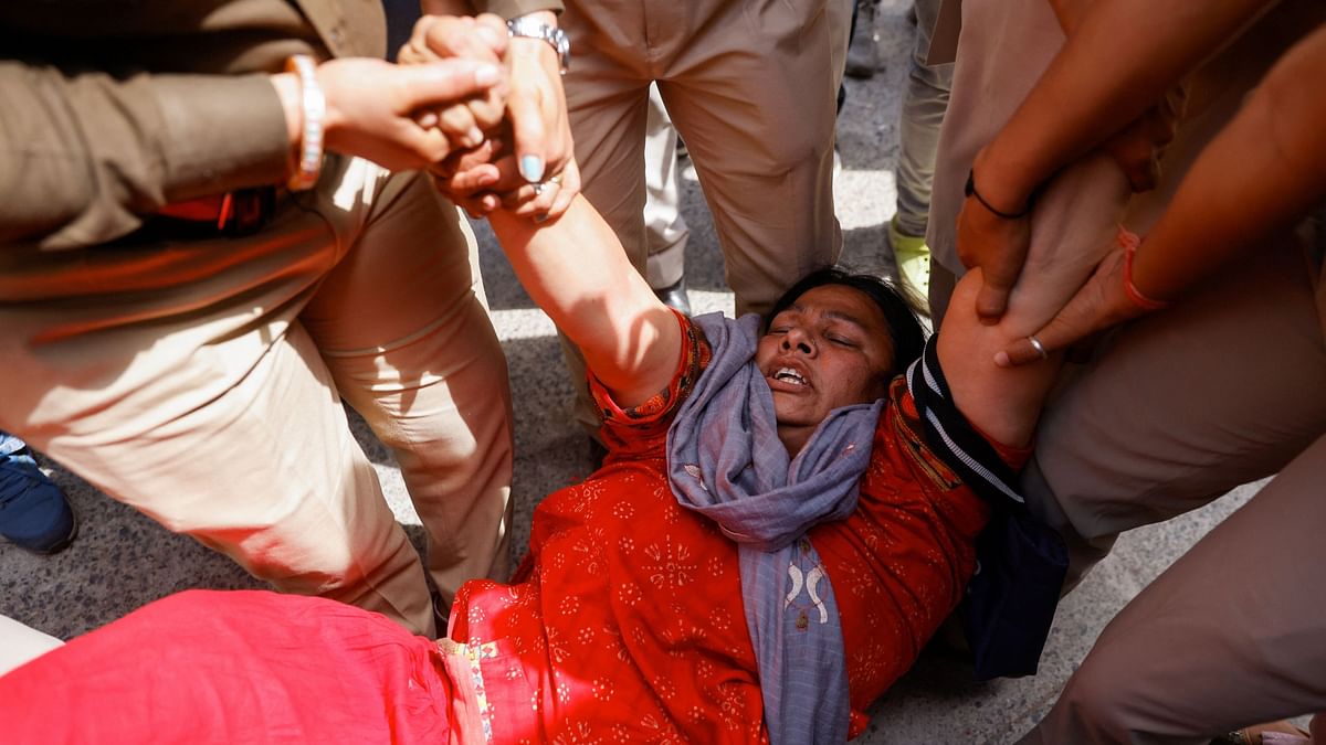 Police detain a supporter of the AAP during a protest after the arrest of Delhi Chief Minister Arvind Kejriwal by the Enforcement Directorate, in New Delhi.