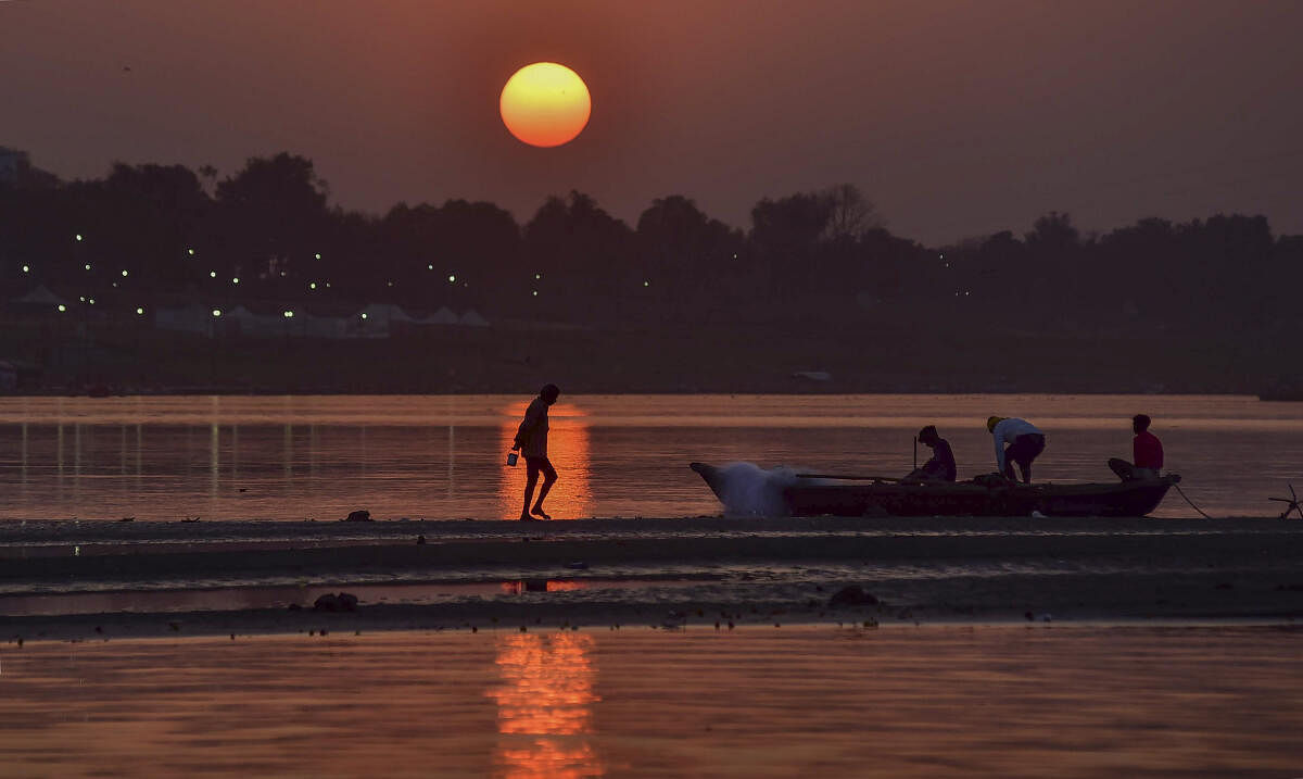 Fishermen during sunset at the Sangam amid the ongoing Magh Mela festival, in Prayagraj. 