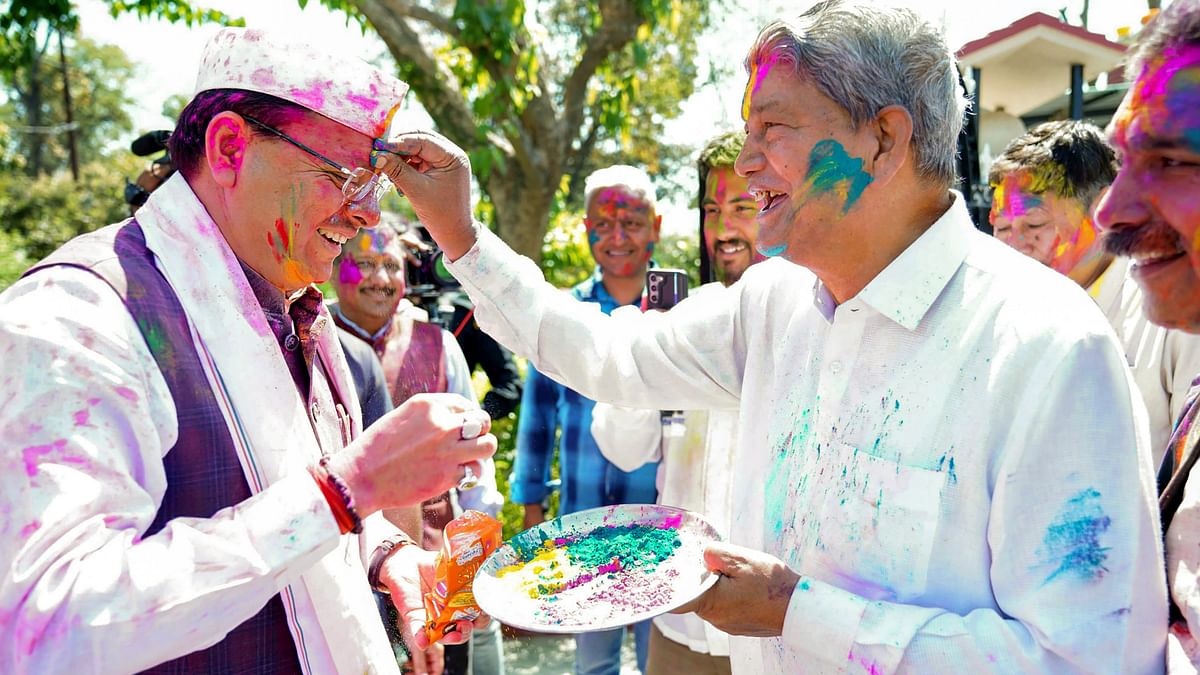 Former CM Harish Rawat is seen applying colour on Uttrakhand Chief Minister Pushkar Singh Dhami during Holi celebrations, in Dehradun.