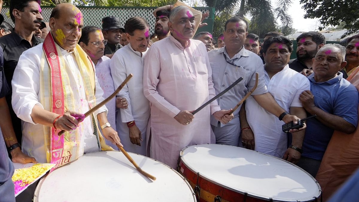 Defence Minister Rajnath Singh plays drums during Holi celebrations at his residence in New Delhi.