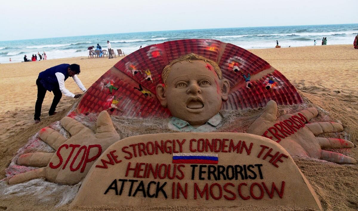 Sand artist Sudarsan Pattnaik gives final touches to a sculpture condemning the Moscow concert hall attack at the beach in Puri