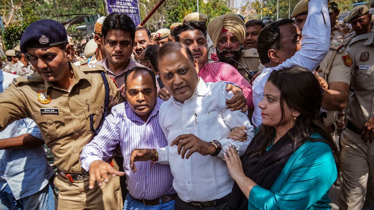 Security personnel detain AAP leader Somnath Bharti during the party's protest outside Patel Chowk metro station against the arrest of Delhi CM Arvind Kejriwal.