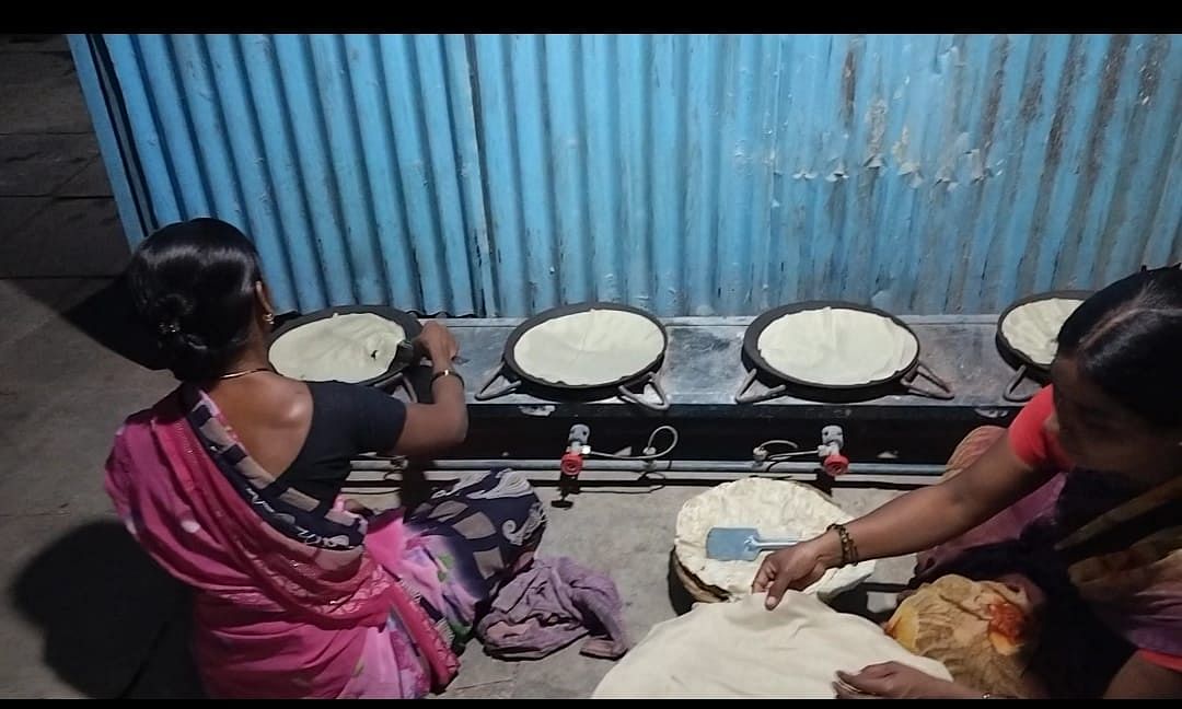 Women cook the rolled-out rottis. 