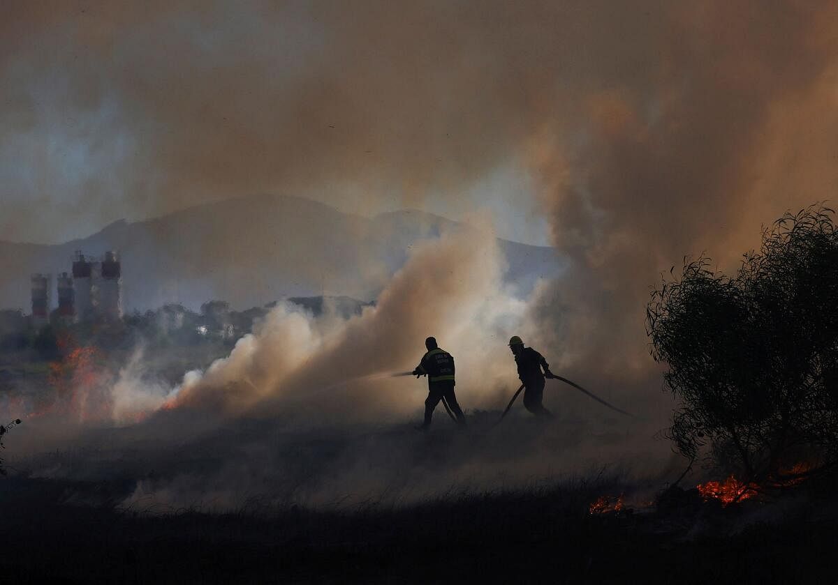 Firefighters work to extinguish a vegetation fire near Hanover Park on the Cape Flats, in Cape Town, South Africa, March 11, 2024.