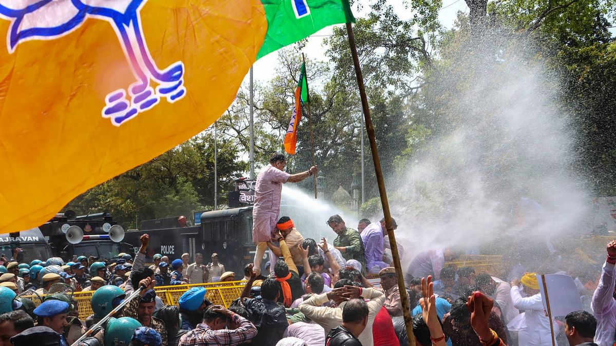 Security personnel use water cannon to disperse BJP workers during their protest demanding the resignation of Delhi Chief Minister Arvind Kejriwal over his arrest by the ED in connection with an excise policy-linked money-laundering case, in New Delhi.