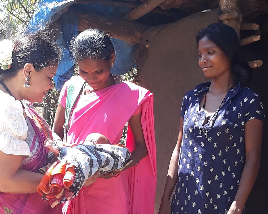 ASHA worker Susheela Sannappa (middle) checks on the health of an infant in a tribal hamlet in D B Kuppe range.