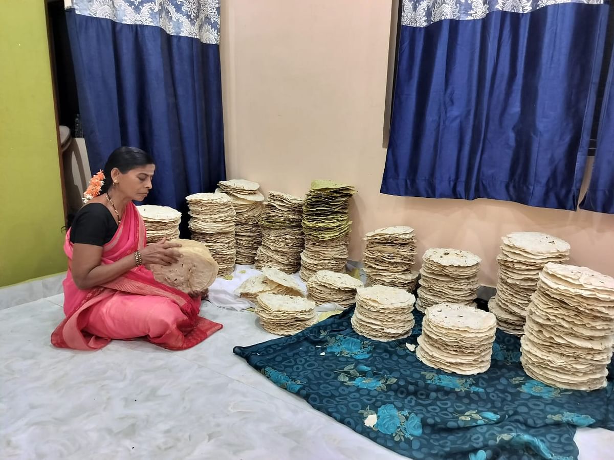 A woman counts and arranges jolada rottis.