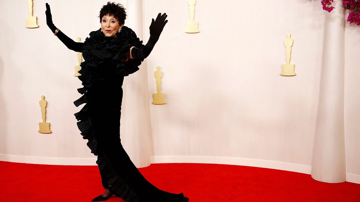 Rita Moreno arrived in a black gown with ruffles at the neck and down the front.