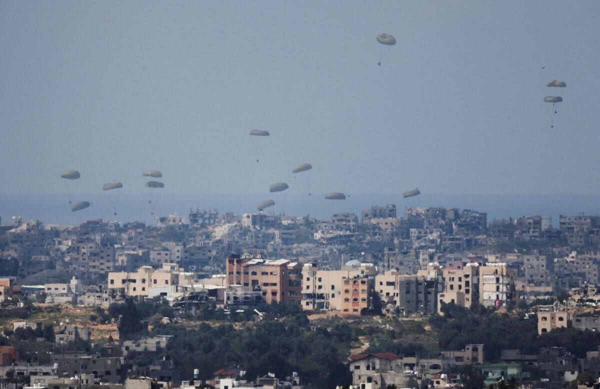 Aid packages fall over northern Gaza, after being dropped from a military aircraft, amid the ongoing conflict between Israel and the Palestinian group Hamas, as seen from Israel's border with Gaza, in southern Israel, March 14, 2024.