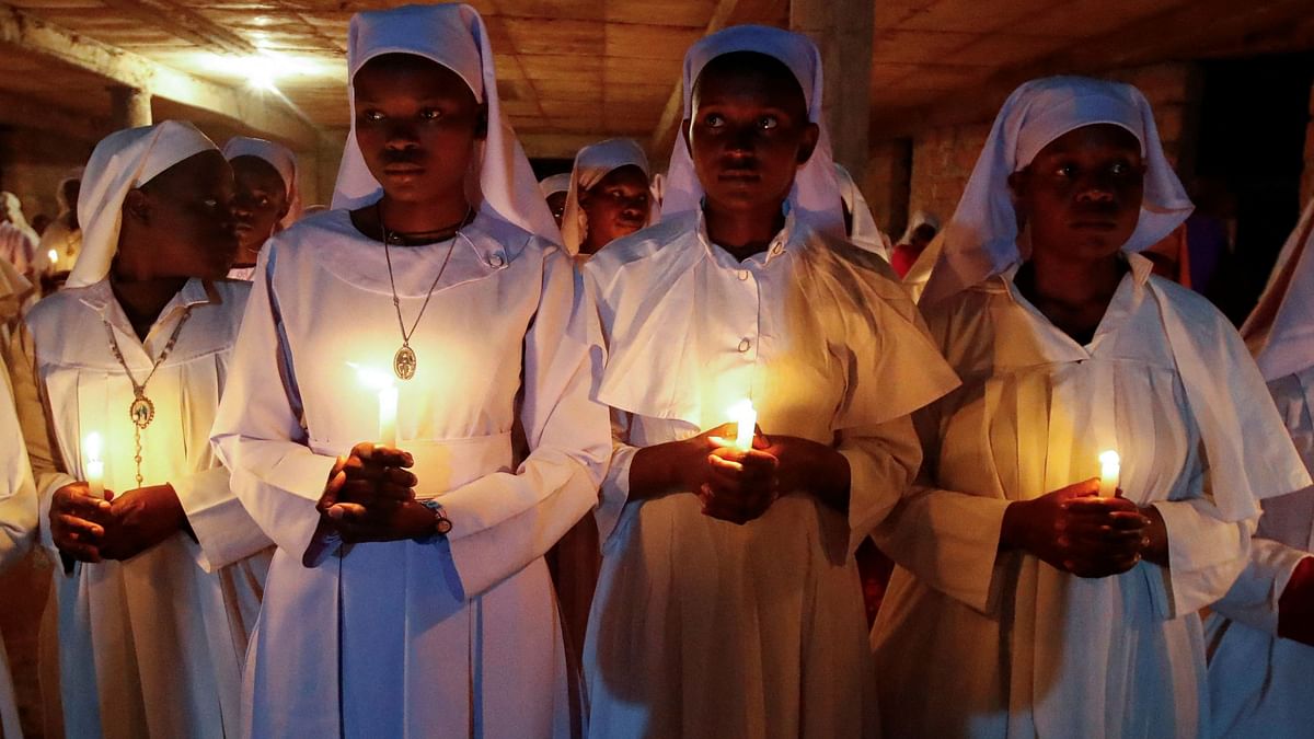 Worshippers hold candles during Easter vigil mass at the St. Joanes, Legio Maria of African Church Mission within Fort Jesus in Kibera district of Nairobi, Kenya.