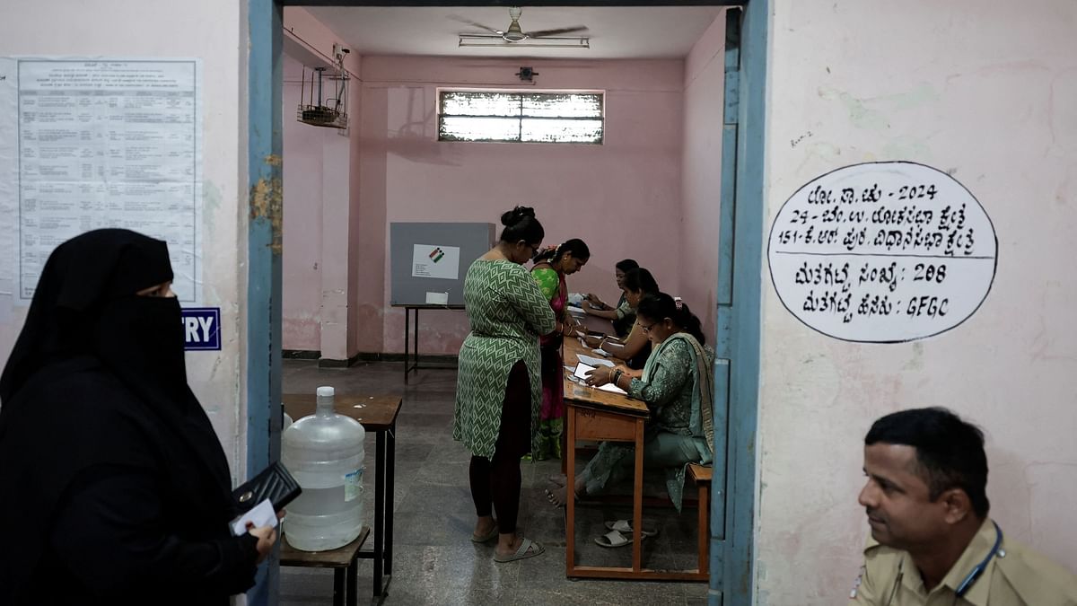 People vote at a polling station during the second phase of the general elections, in Bengaluru.