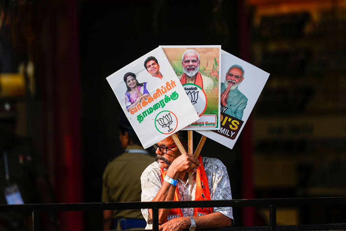 A BJP supporter holds placards during Prime Minister Narendra Modi's roadshow in support of BJP's candidate from South Chennai constituency, ahead of the Lok Sabha elections, in Chennai, Tuesday.