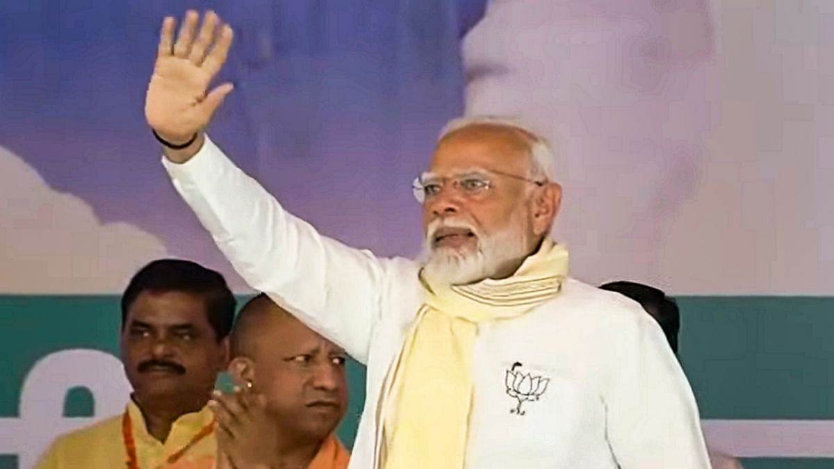 Prime Minister Narendra Modi waves at supporters during a public meeting organised for BJP's campaign for the Lok Sabha elections, in Amroha.