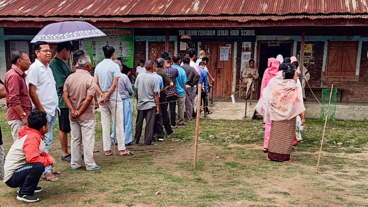 People wait to cast their votes for Lok Sabha elections, in Manipur.