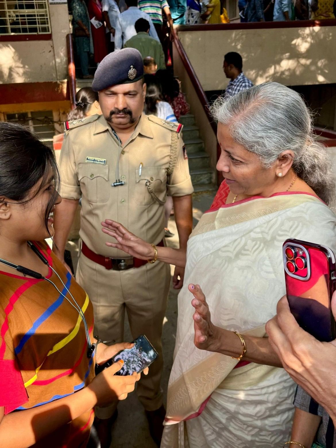 Finance Minister Nirmala Sitharaman interacts with voters at the polling booth in Jayanagar, Bengaluru.