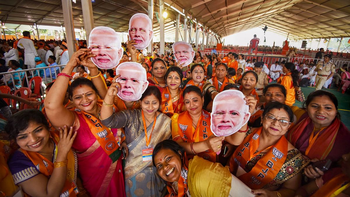 BJP supporters holding masks of Prime Minister Narendra Modi attend his public meeting ahead of Lok Sabha elections, in Gaya.