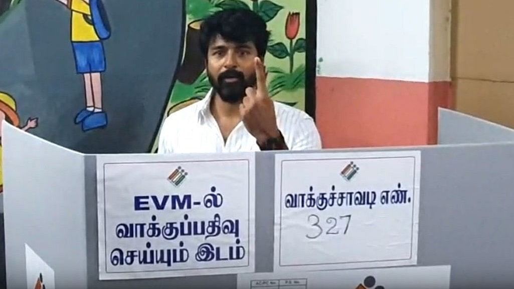 Actor Sivakarthikeyan shows his ink marked finger after casting his vote, at a polling station in Chennai.