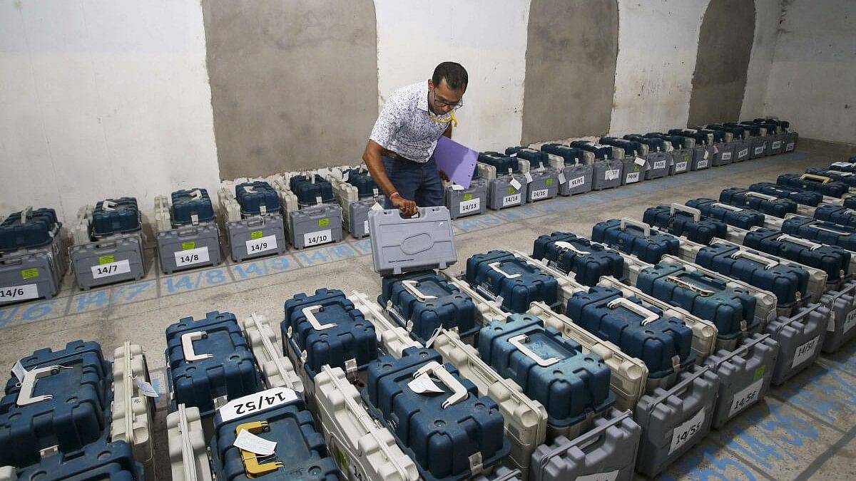 A polling official checks Electronic Voting Machines (EVM) kept inside a strong room ahead of the first phase of voting for Lok Sabha elections, in Agartala. 