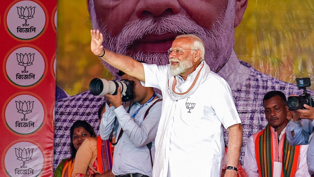 Prime Minister Narendra Modi waves to supporters during an election campaign rally ahead of the upcoming Lok Sabha polls, in Cooch Behar.