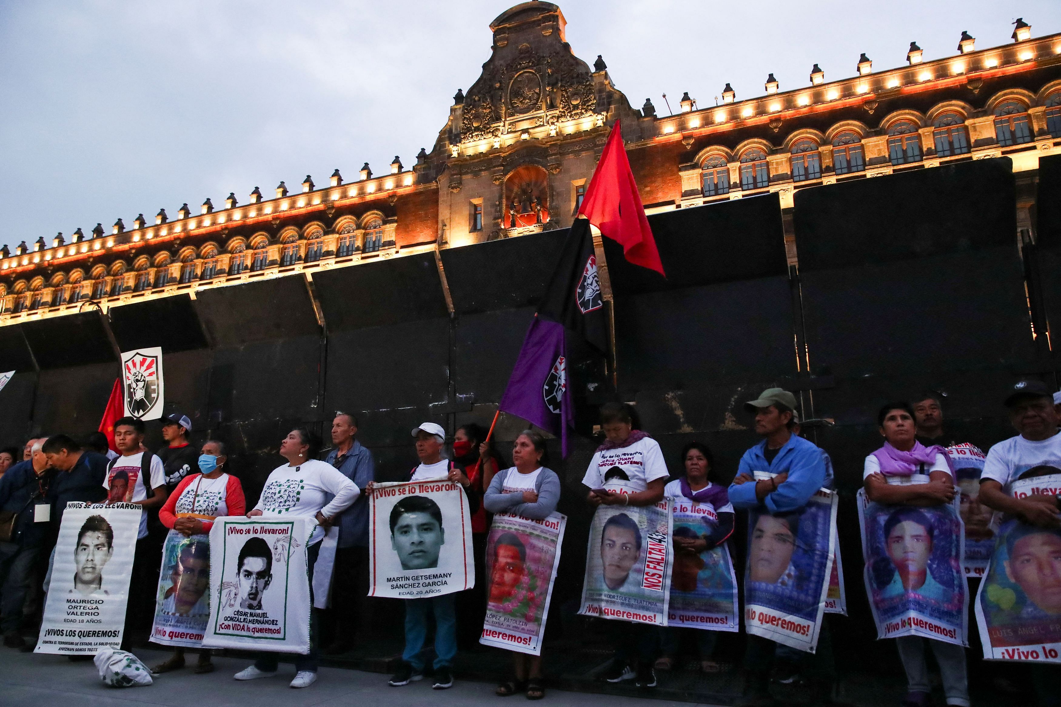 Relatives hold banners with images of the missing students from Ayotzinapa Teacher Training College outside National Palace, during a march to demand justice for their loved ones, in Mexico City, Mexico April 26, 2024. 