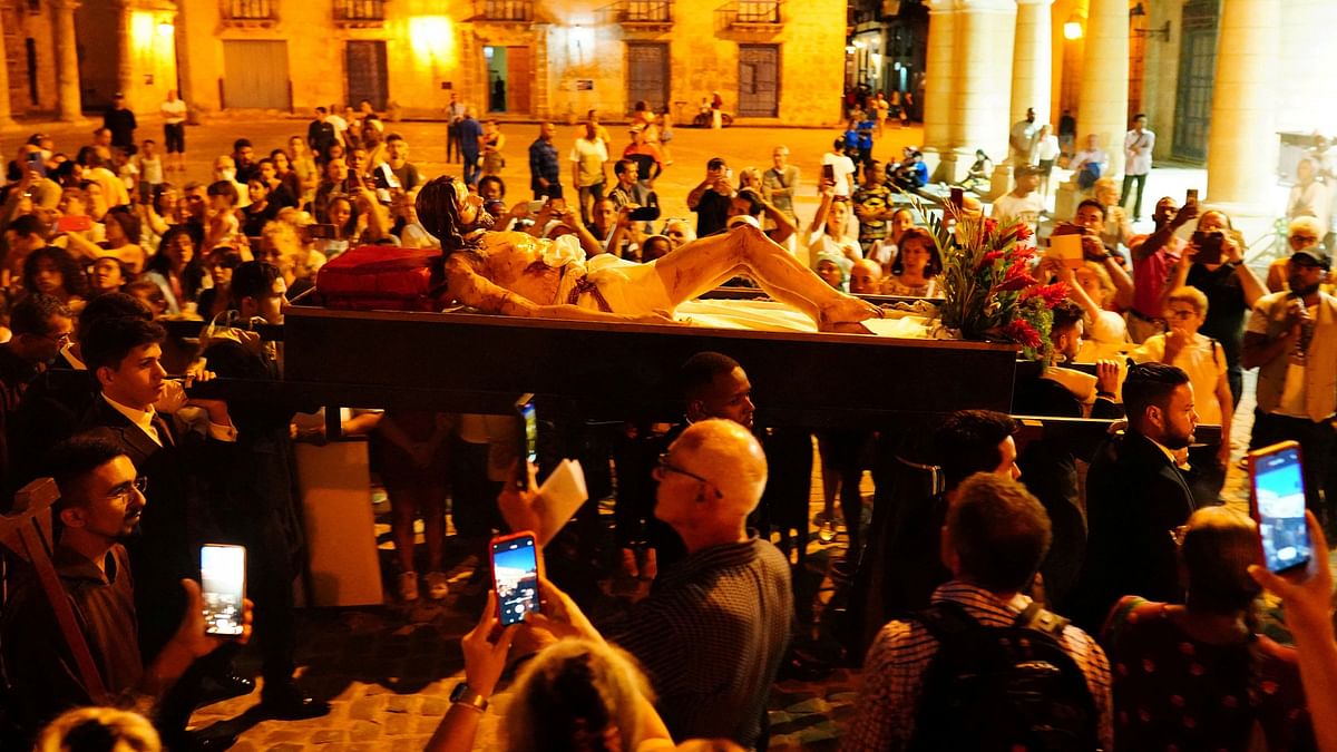 People film a statue of Jesus Christ in a procession during Holy Week celebrations in downtown Havana, Cuba.