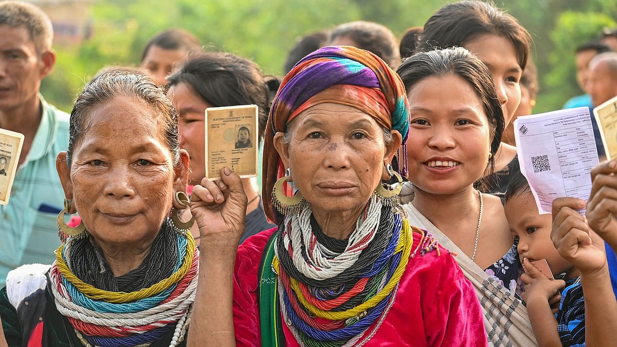 Bru (ethnic group) people show their ID cards as they wait to cast their votes for the second phase of Lok Sabha elections, at a special polling centre set up about 170 km away from Agartala.