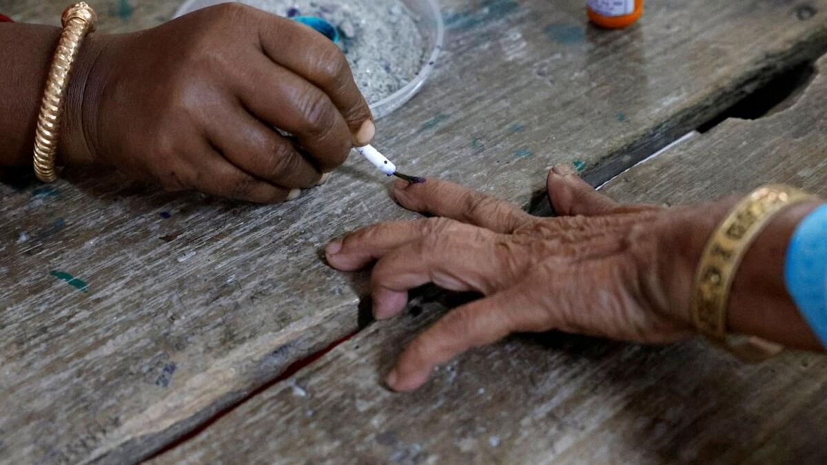 A woman gets her finger inked before casting her vote at a polling station during the first phase of the general election, in Alipurduar district of the eastern state of West Bengal, India, April 19, 2024.