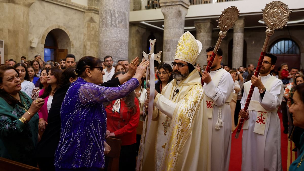 A worshipper touches a cross during an Easter vigil service at the Grand Immaculate Church in Al-Hamdaniya, Iraq.
