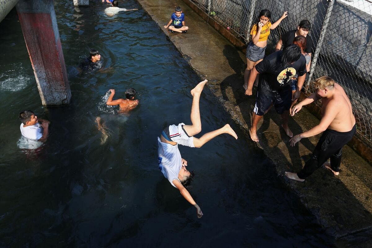 A man is launched into El Cuilio pool at El Coro neighborhood during a heat wave in San Salvador, El Salvador April 18, 2024.