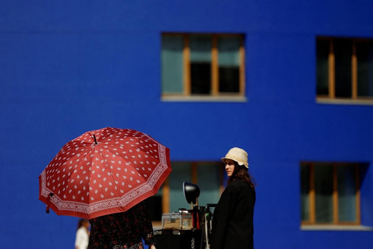 A woman protects herself from the sun during hot weather in Bilbao, Spain, April 13, 2024.