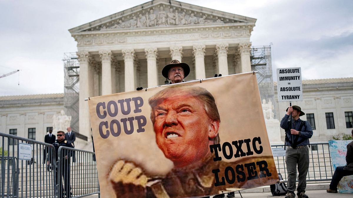 A demonstrator holds a sign outside the U.S. Supreme Court as the justices hear arguments on former President Trump’s claim of presidential immunity over criminal charges over his efforts to overturn the 2020 presidential election results in Washington, U.S., April 25, 2024. 