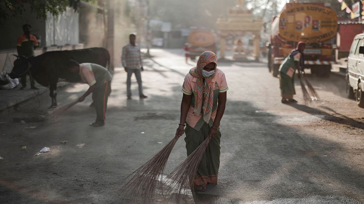Workers from the Bruhat Bengaluru Mahanagara Palike (BBMP) clean the area outside a polling station a day ahead of the second phase of India's general election, in Bengaluru.