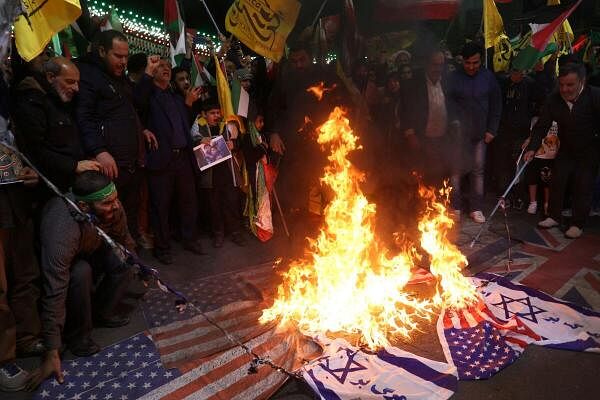 Protesters burn U.S. and Israeli flags during an anti-Israel protest in Tehran.