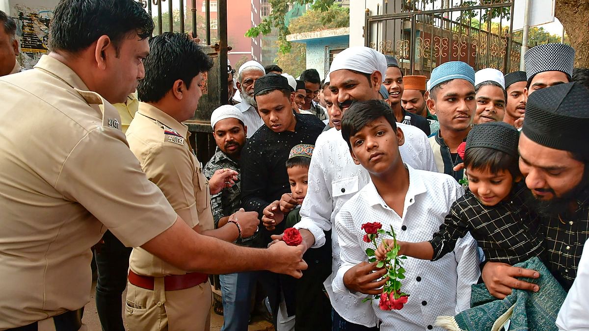 Policemen greet Muslim devotees with roses on the occasion of Eid-ul-Fitr, at YMCA ground, in Mumbai.