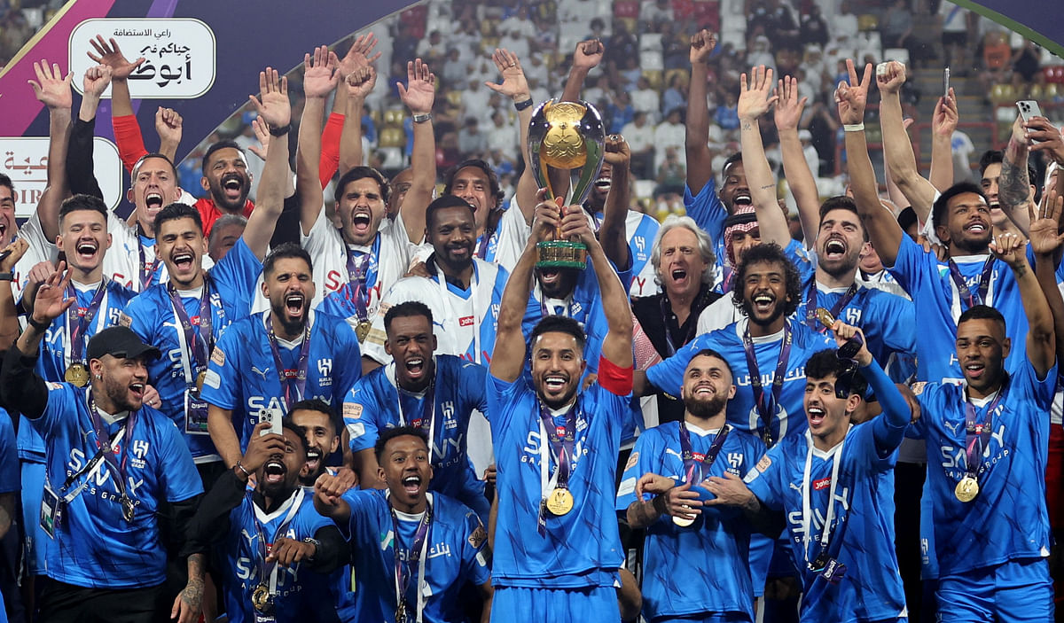 Al Hilal's Salem Al-Dawsari lifts the trophy with teammates after winning the Saudi Super Cup final.