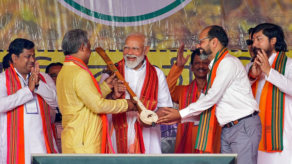 PM Modi being presented a memento during an election campaign rally in support of NDA candidates ahead of Lok Sabha elections, in Cooch Behar.