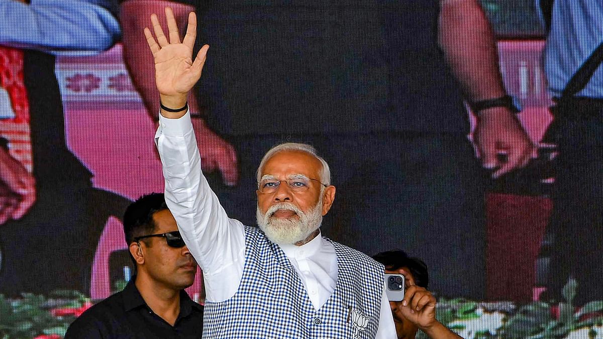 Prime Minister Narendra Modi waves to supporters during a public meeting in Nalbari district, Assam.