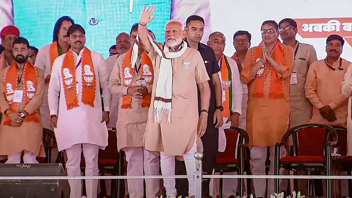 PM Modi waves at supporters during a public meeting ahead of Lok Sabha elections, in Churu, Rajasthan.