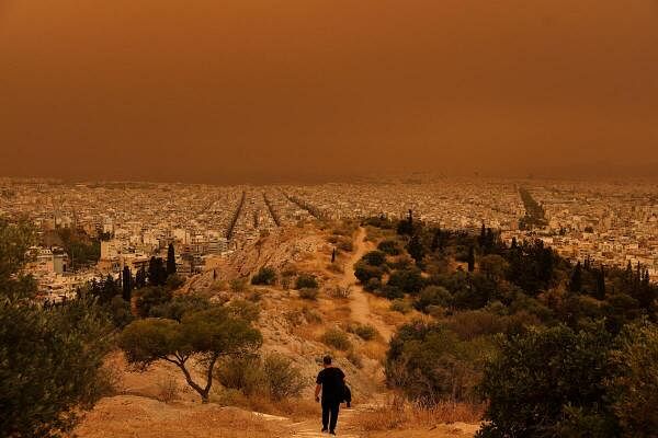 A man makes his way at a hill as African dust from the desert of Sahara covers the city of Athens, Greece, April 23, 2024.