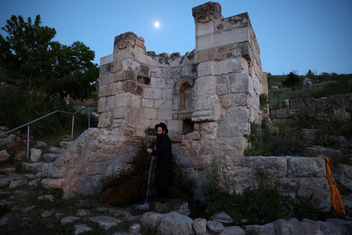 An Ultra-Orthodox Jew takes part in the "Mayim Shelanu" ceremony in which water is collected from a natural spring for the preparation of matza, the traditional unleavened bread eaten during the upcoming Jewish holiday of Passover, near Jerusalem in the Israeli-occupied West Bank, April 21, 2024. 