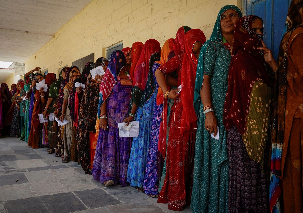 Women stand in a queue to cast their vote at a polling station during the second phase of the general elections, in Barmer, Rajasthan, India, April 26, 2024. 