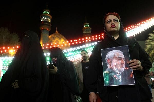 An Iranian woman holds a picture of the late military officer Qassem Soleimani during an anti-Israel protest in Tehran.