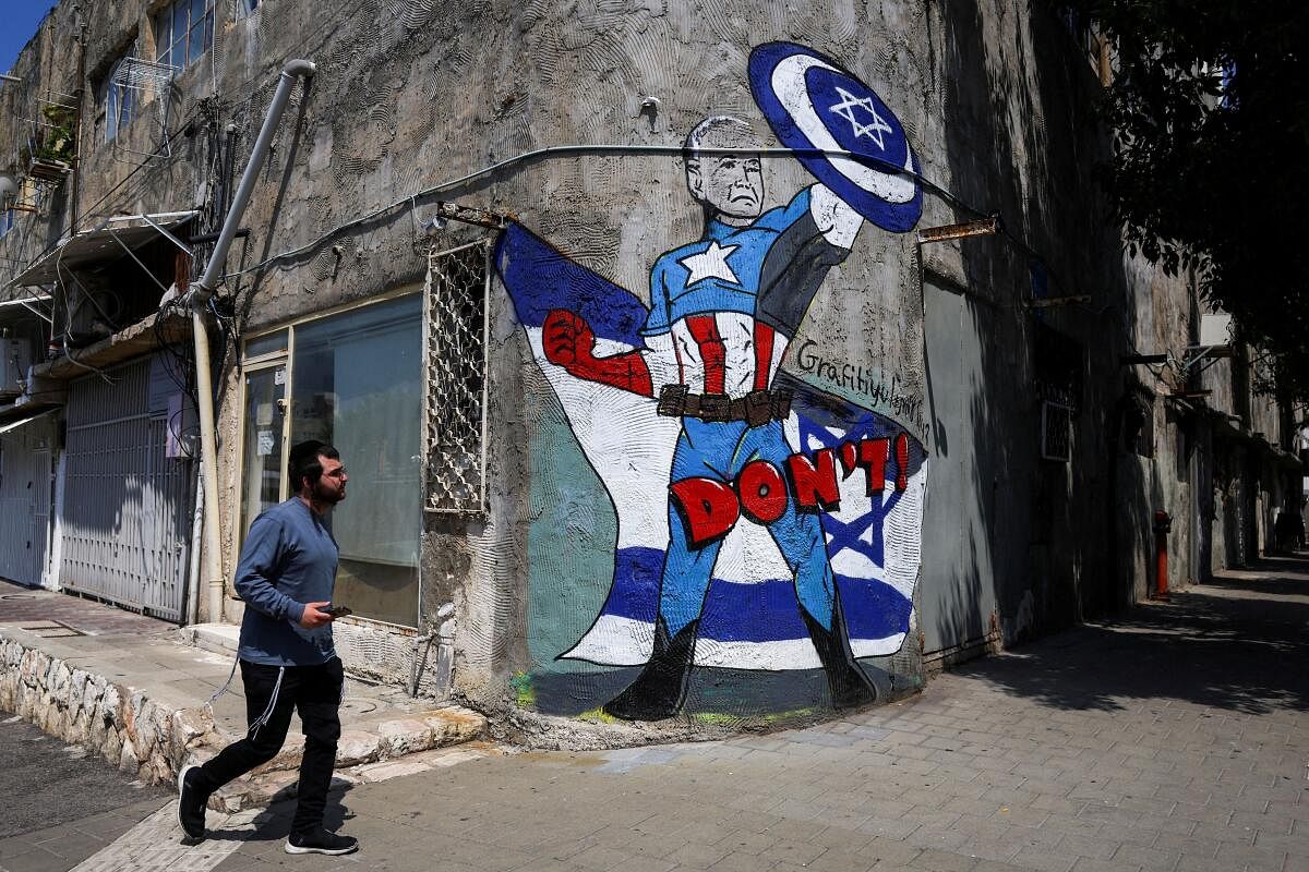 A man walks past graffiti that depicts US President Joe Biden as the superhero Captain America in Tel Aviv, Israel, April 14, 2024.