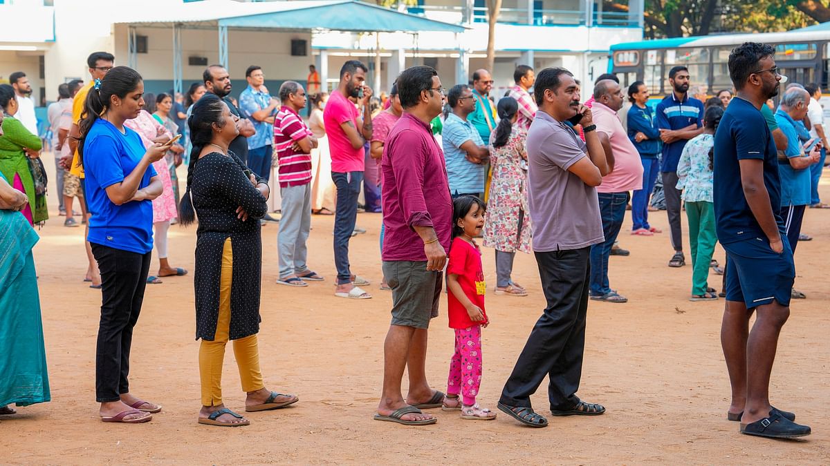 People wait in queues to vote for the 2nd phase of Lok Sabha polls at a polling station at Rajarajeshwari Nagar, in Bengaluru.