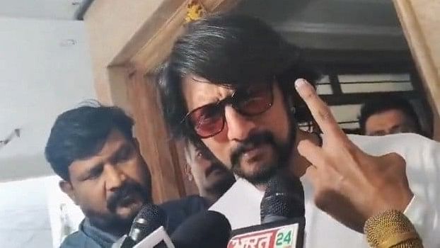 Kichcha Sudeep shows his finger marked with indelible ink after casting his vote for the second phase of Lok Sabha elections, at a polling station in Bengaluru.