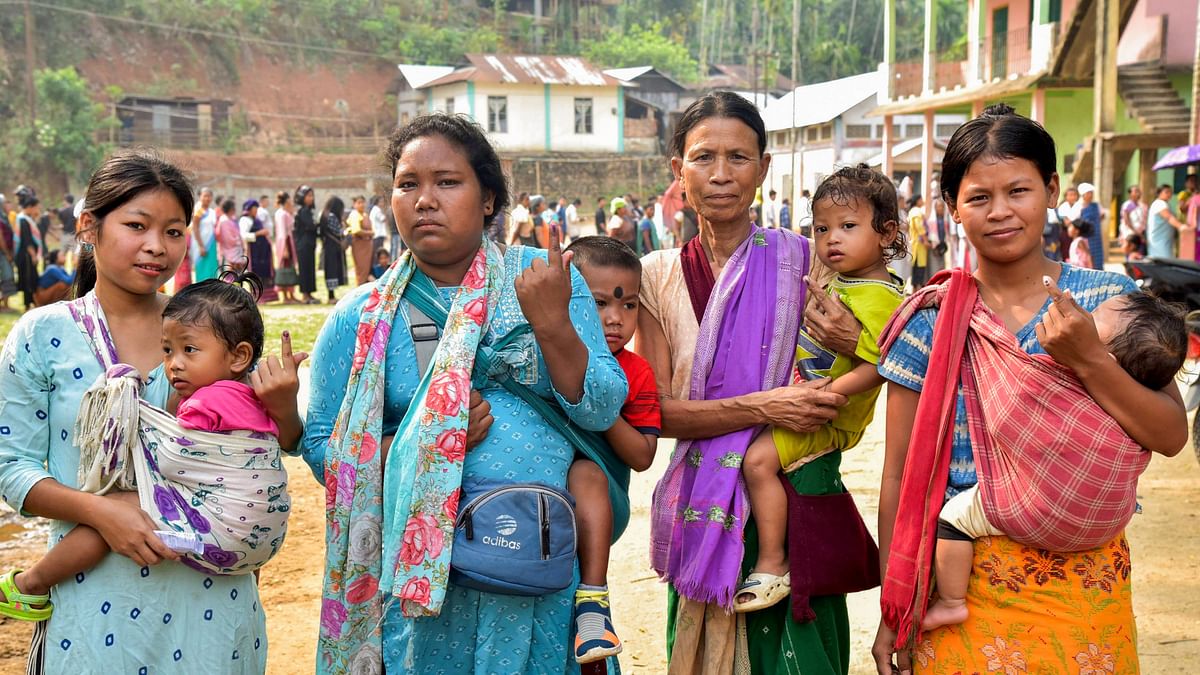 Voters carrying their children show their fingers marked with indelible ink after casting their votes for the first phase of Lok Sabha elections, in Meghalaya.