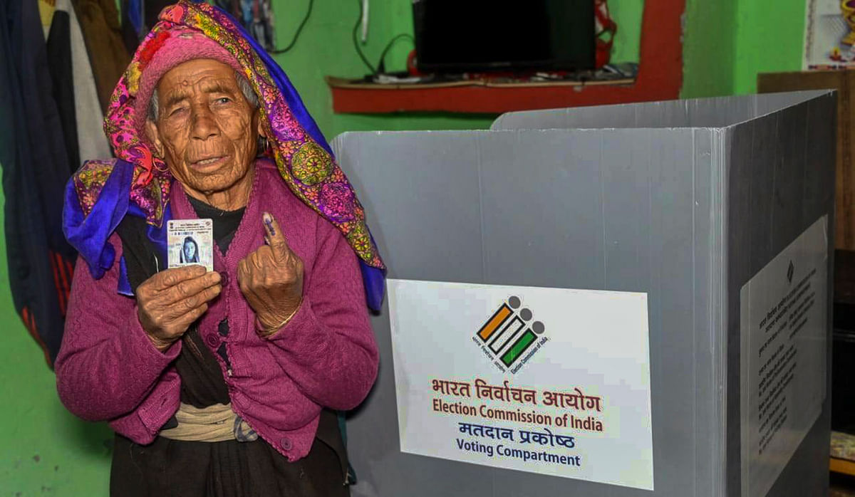 A senior citizen casts her vote via postal ballots for Lok Sabha polls, at her residence, in Chamoli district, Tuesday. 