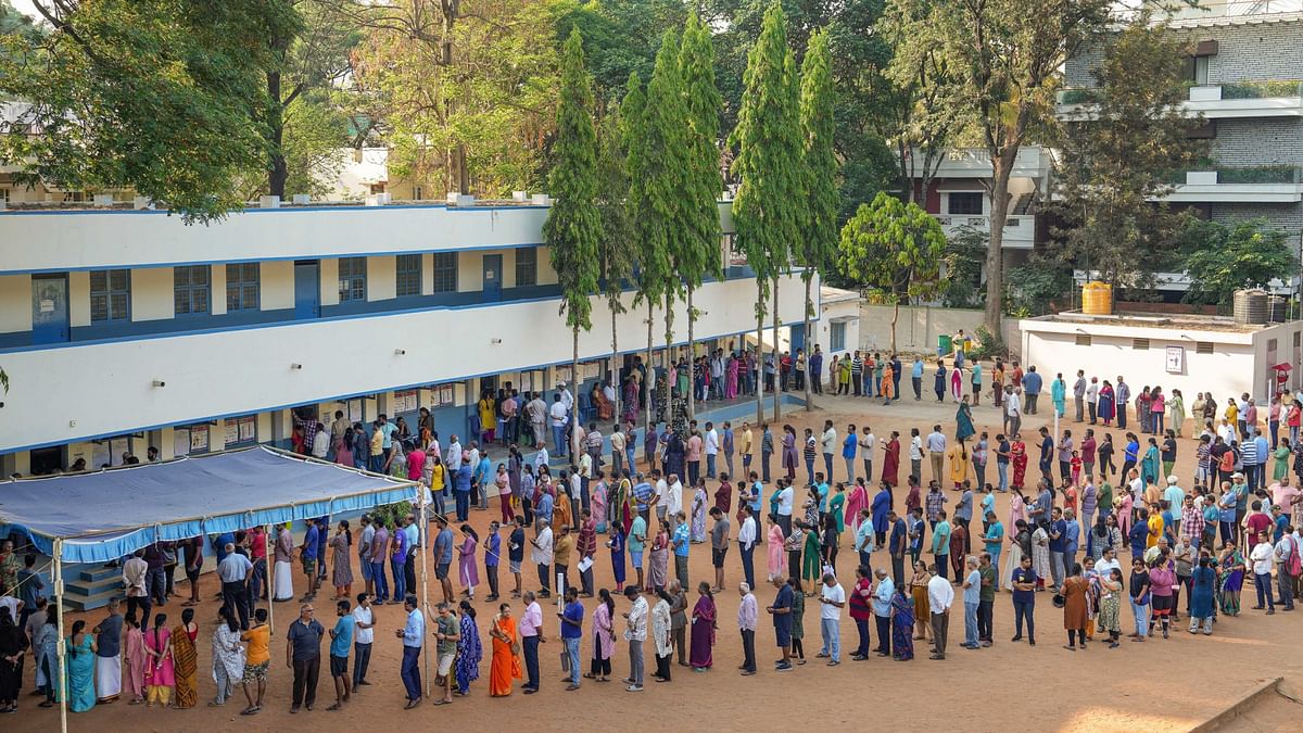 People wait in queues to cast their votes for the 2nd phase of Lok Sabha polls at a polling station at Rajarajeshwari Nagar, in Bengaluru.