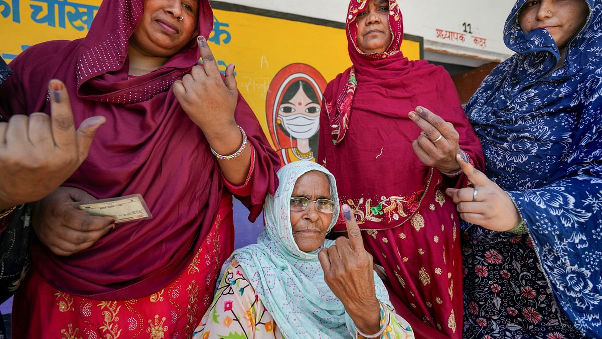 Voters show their fingers marked with indelible ink after casting their votes for the second phase of Lok Sabha elections, in Meerut.